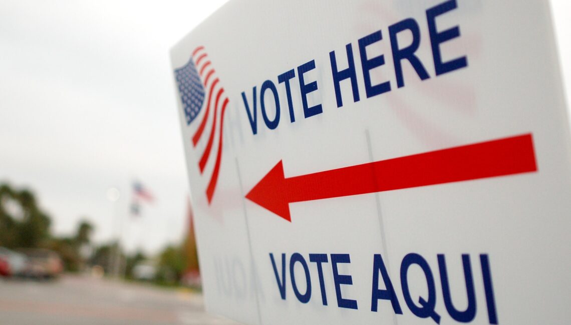 "Vote here, vote aqui" by whiteafrican is licensed under CC BY 2.0.